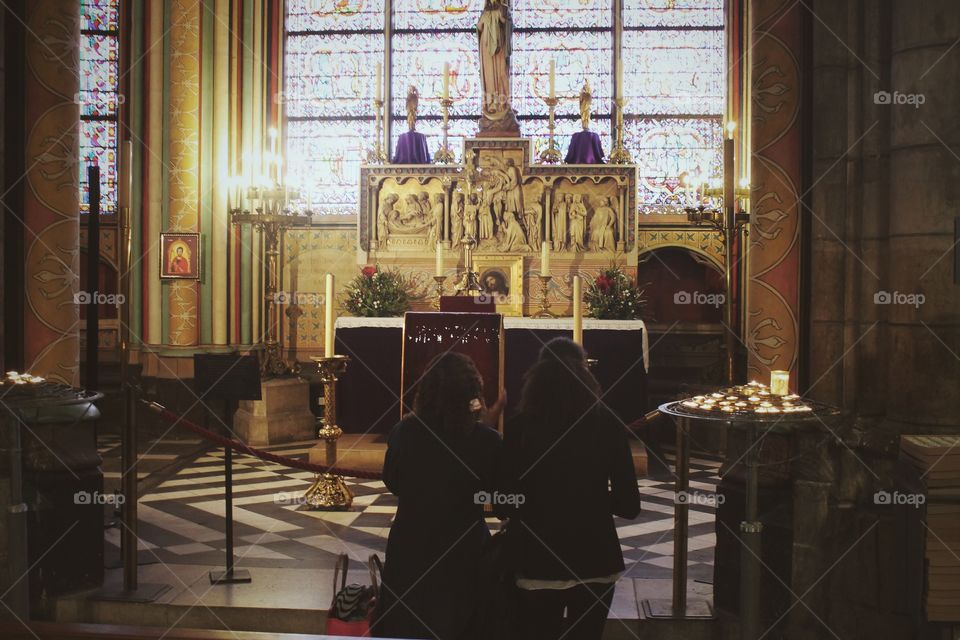 Couple prays in Paris France cathedral. 