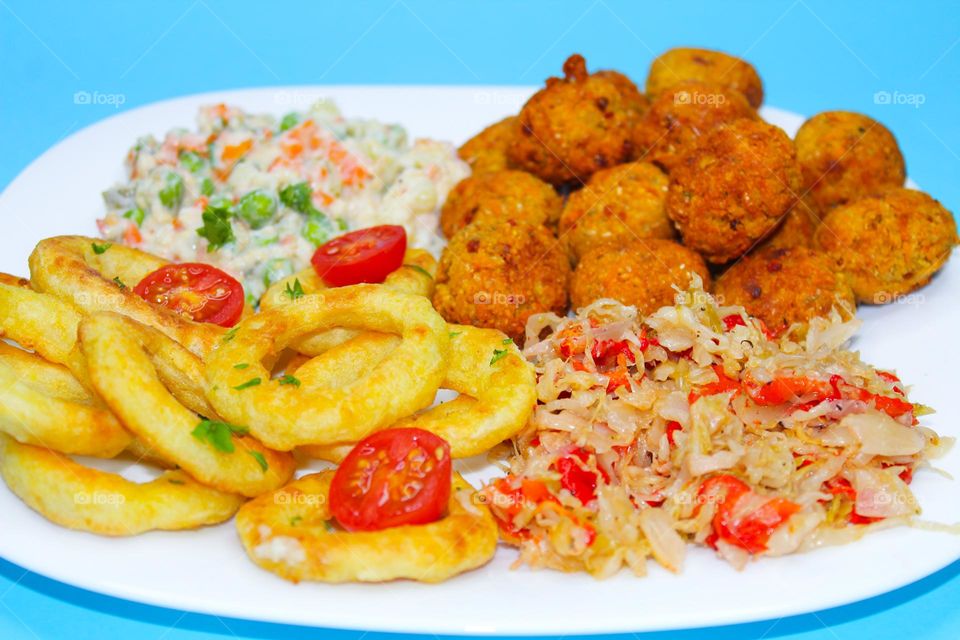 Falafel, sauerkraut, vegetables and fried onion rings