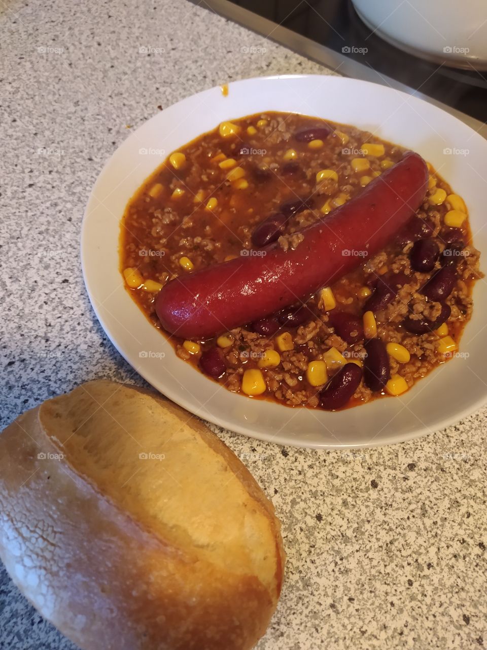 chilli con carne with rolls and sausage