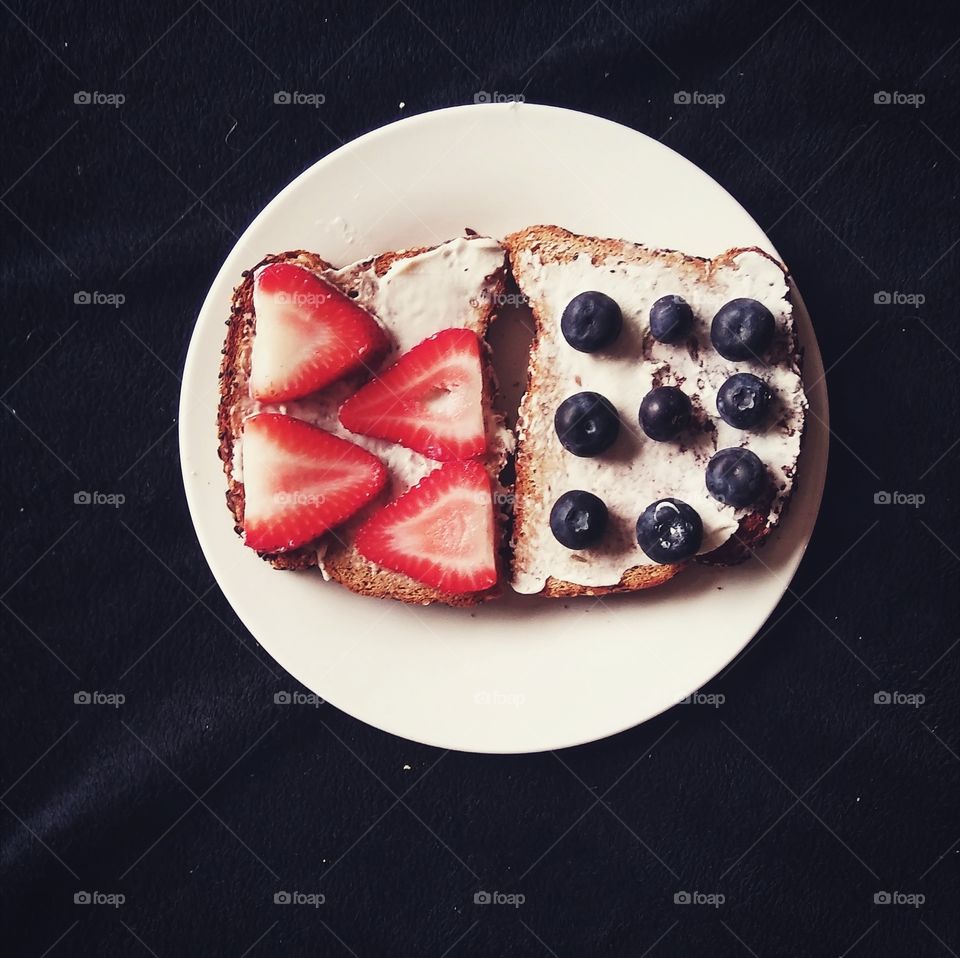 Toast smeared with vegan cream cheese and topped with fresh fruit