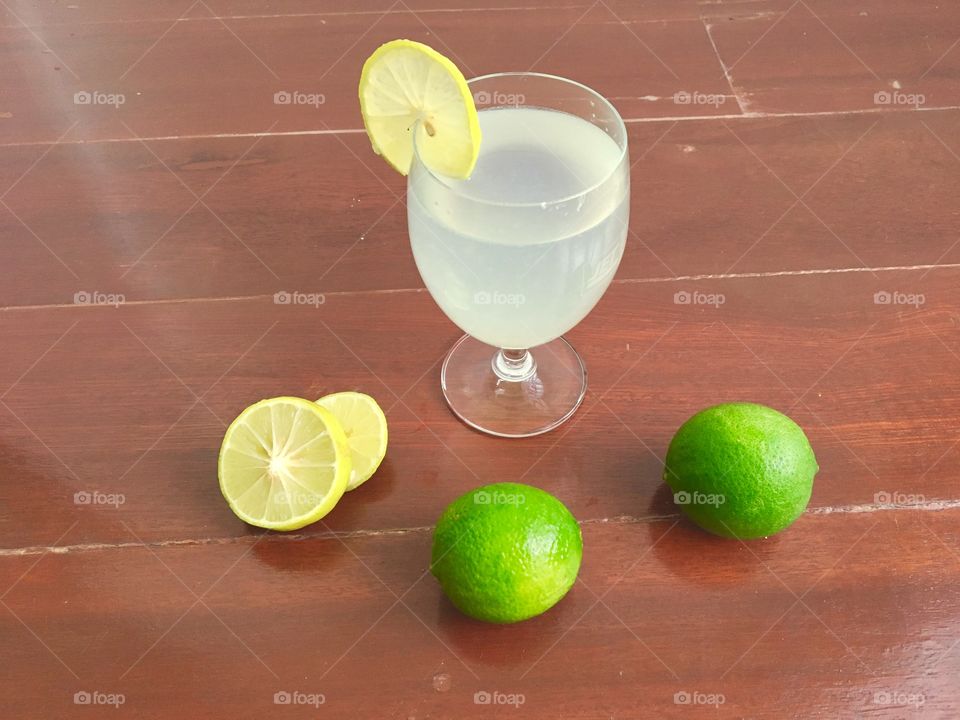 lemonade with fresh slice lemon on wooden table.