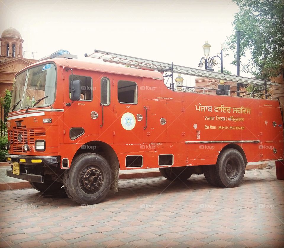 An orange retro firetruck was parked on the street in Jaipur (India).
