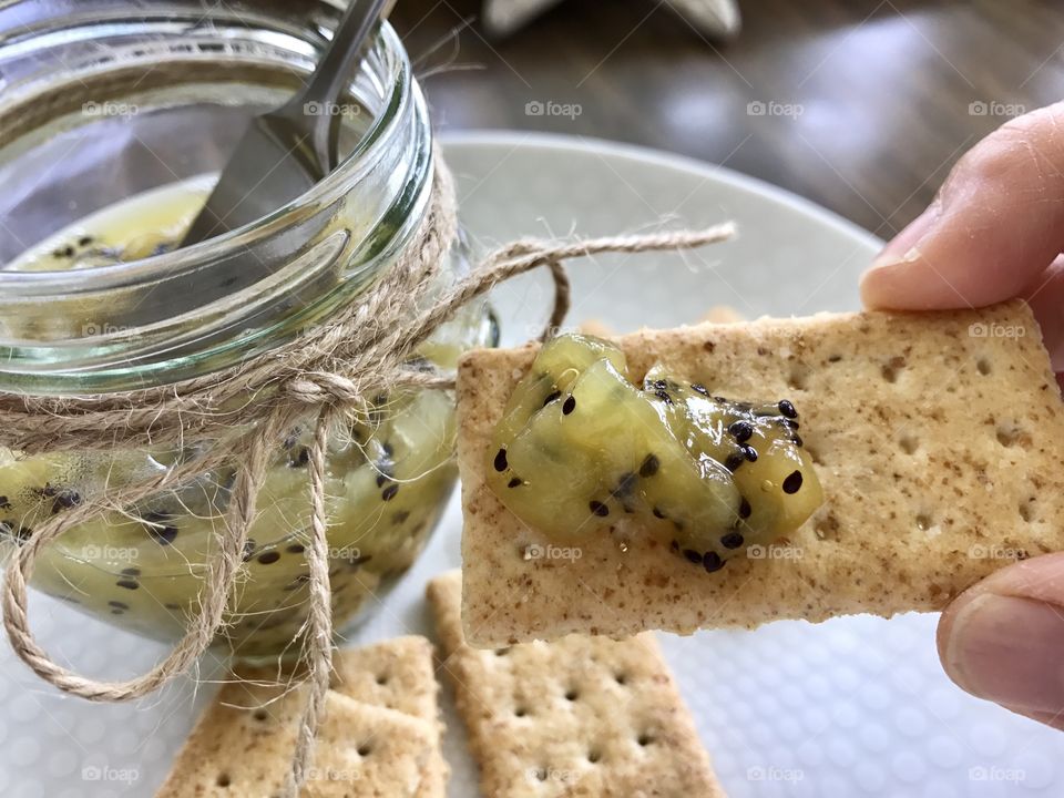 Homemade Kiwi jam and crackers on a plate 