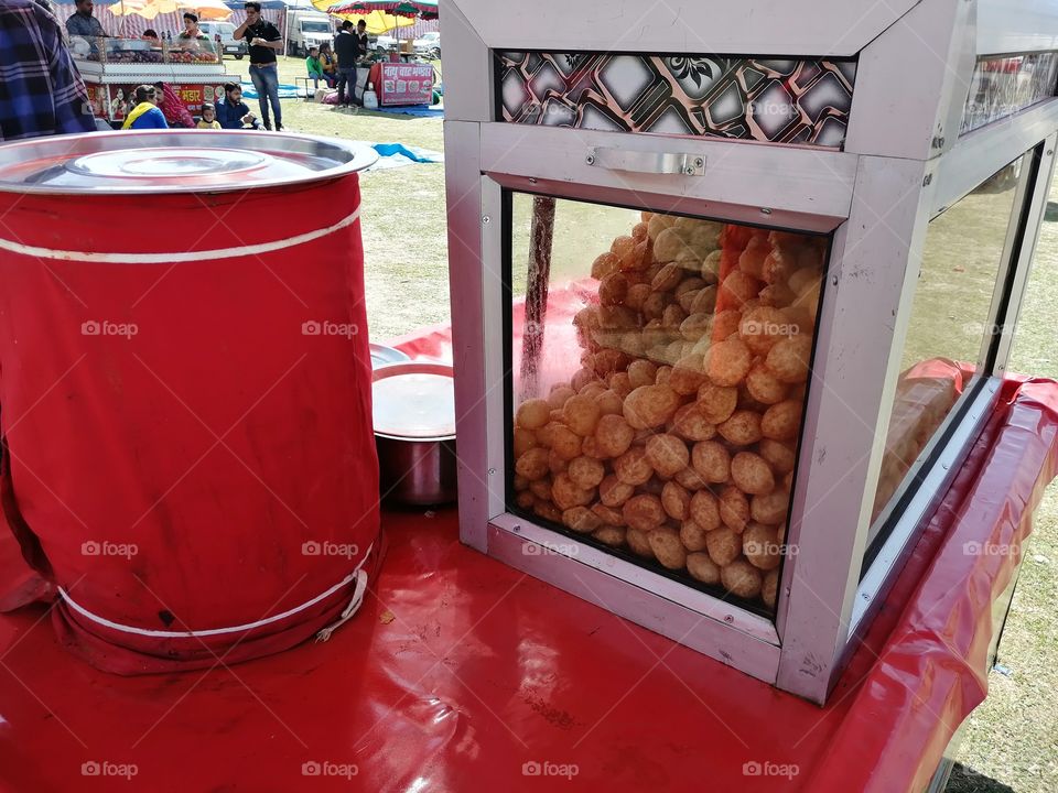 Famous Indian Panipuri stall and famous Indian street food or snacks. . It consists of a round, hollow puri, deep-fried crisp crepe and filled with a mixture of flavored water, tamarind chutney, chili, chaat masala, potato, onion or chickpeas.