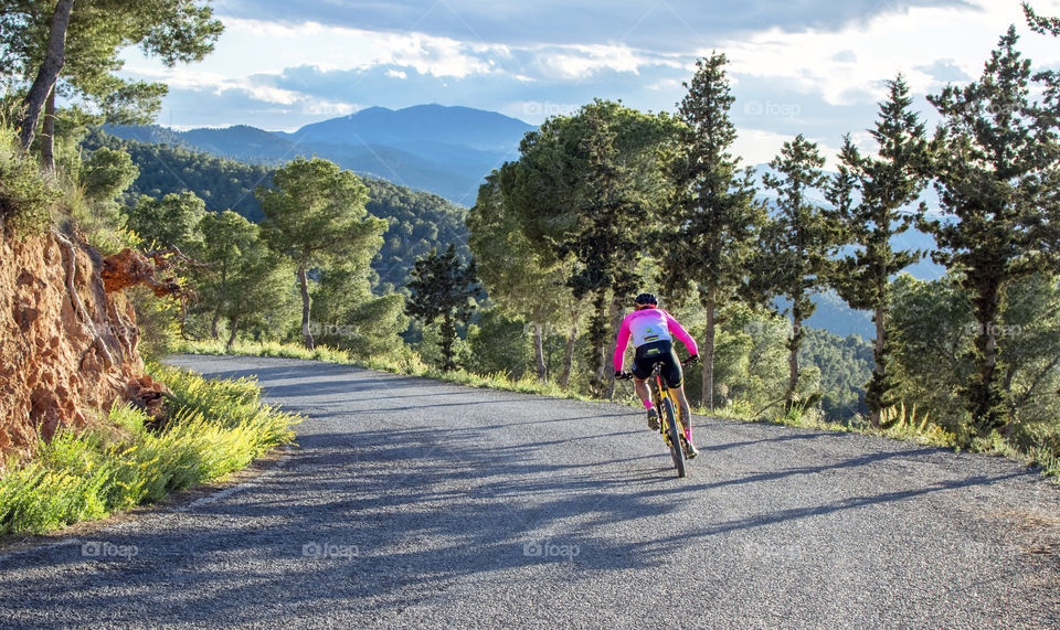 Cyclist descending a mountain road on summer in Spain.