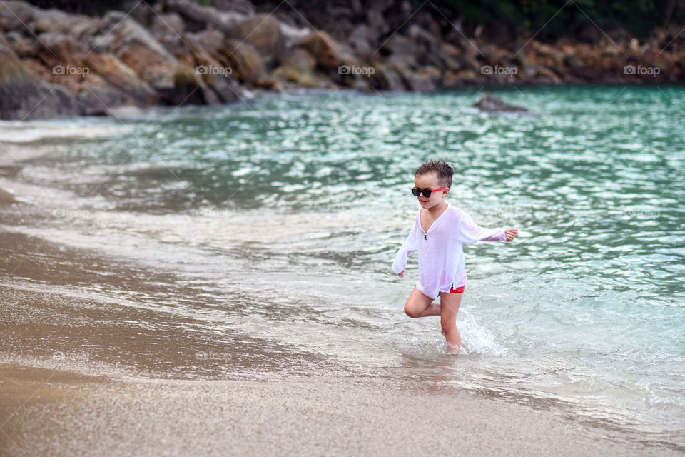 A boy is running on the ocean shore