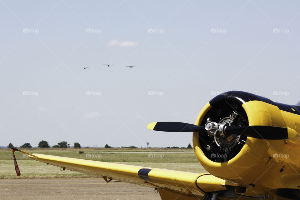 Yellow Aerobatic Aircraft With Formation On Approach