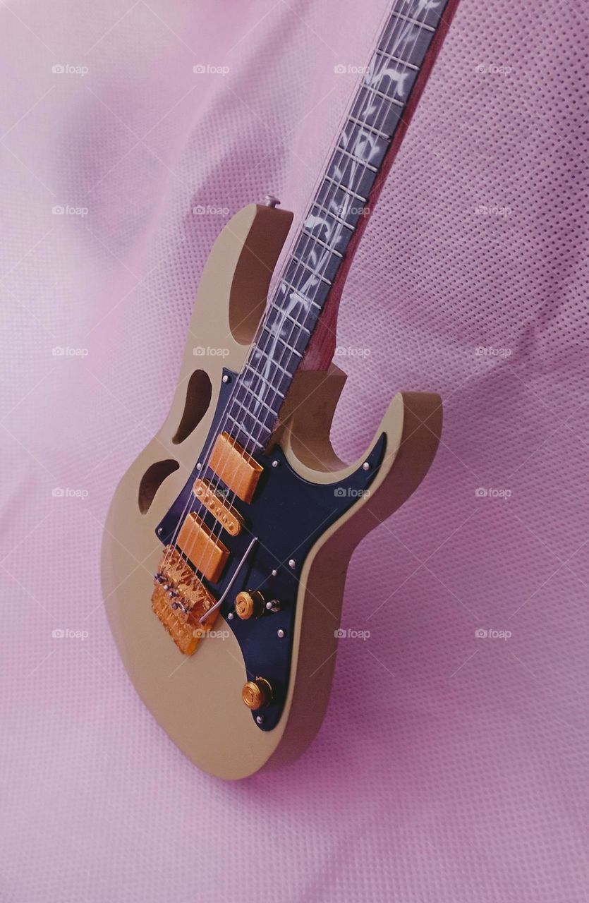 Guitar miniature in pink background