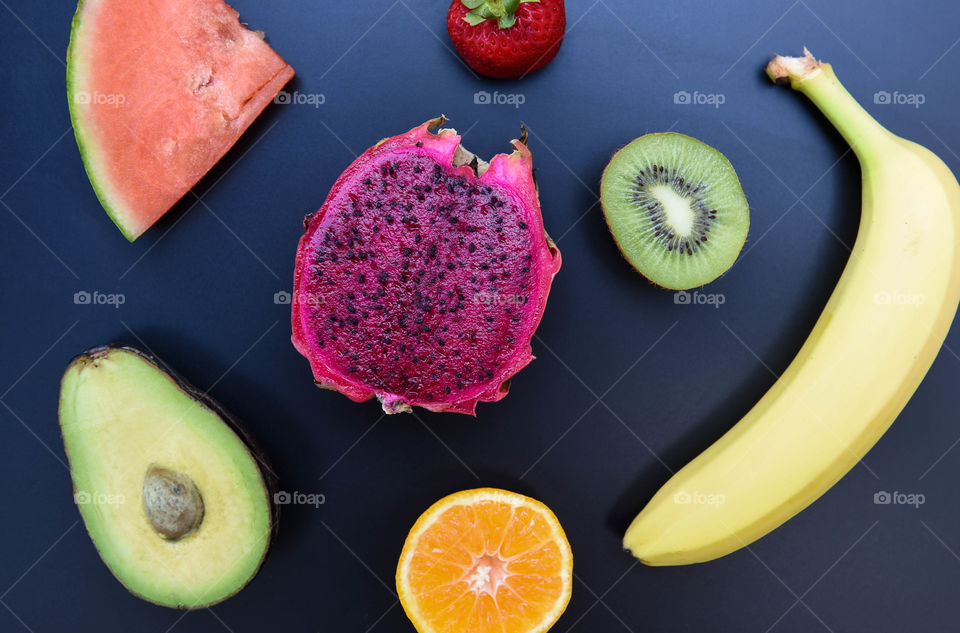 Flat lay of assorted colorful fruits against a black background
