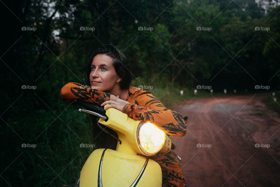 girl in a forest on a moped