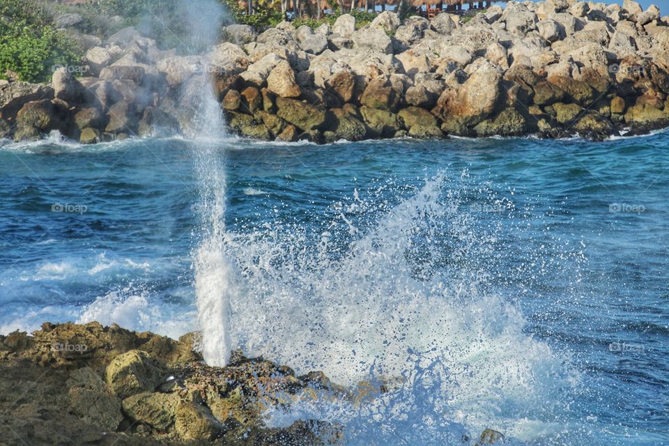 Water coming out of pressure between rocks in surf break