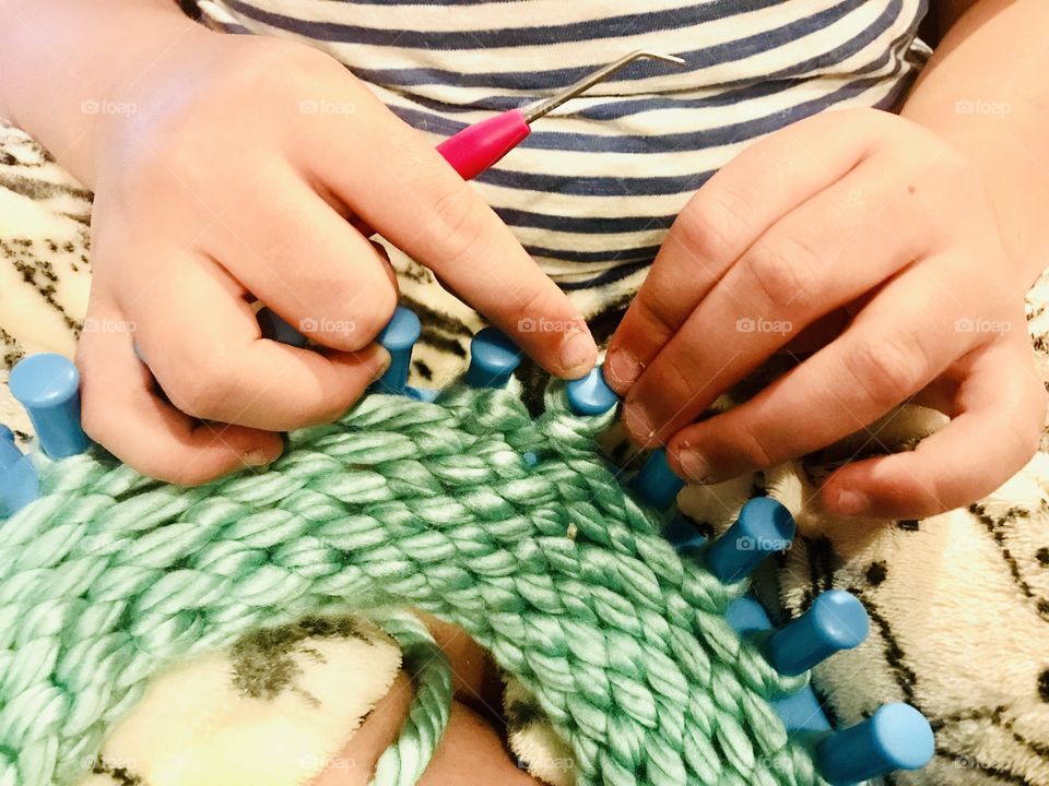 Sweet young girl knitting herself a beautiful greenish bluish handmade accessory!!