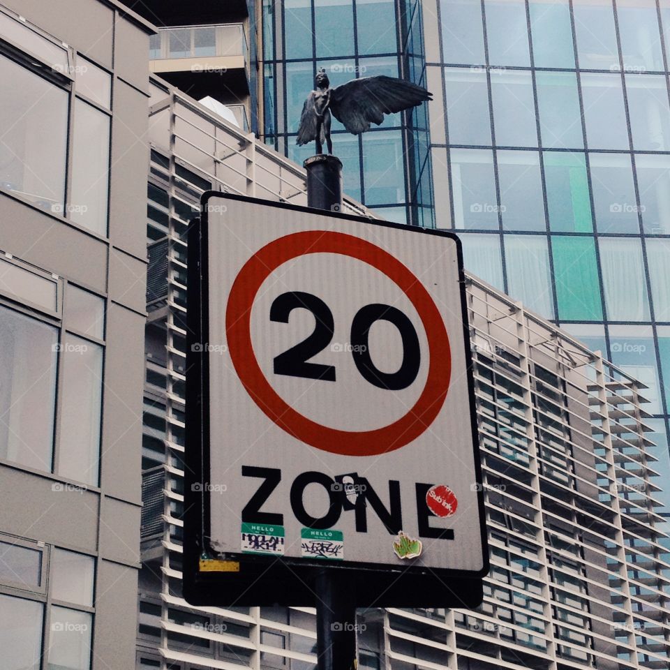 Street art in London. Statute on top of a traffic speed sign in London