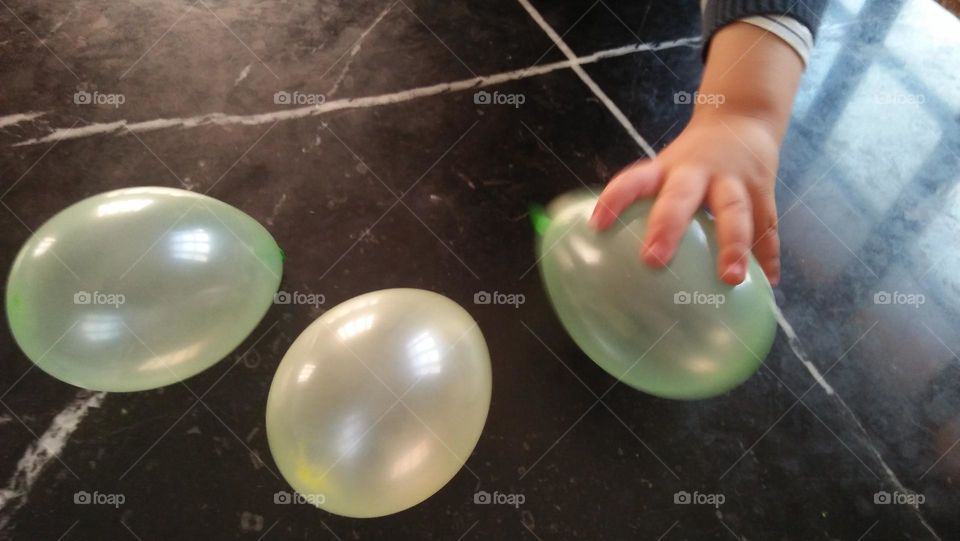 young hand of a boy tries to catch his favorite ballon.