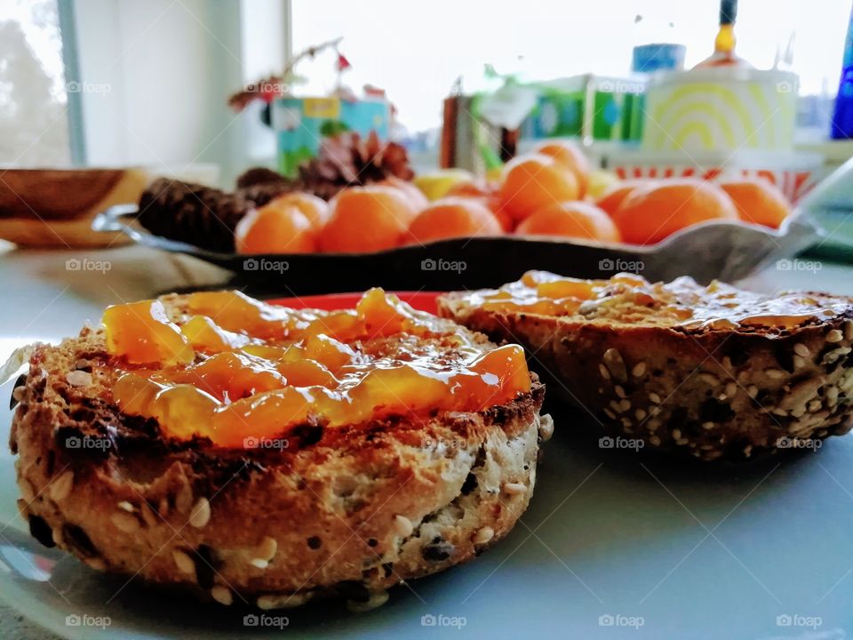 Homemade peach jam spread on whole grain dark rye bread