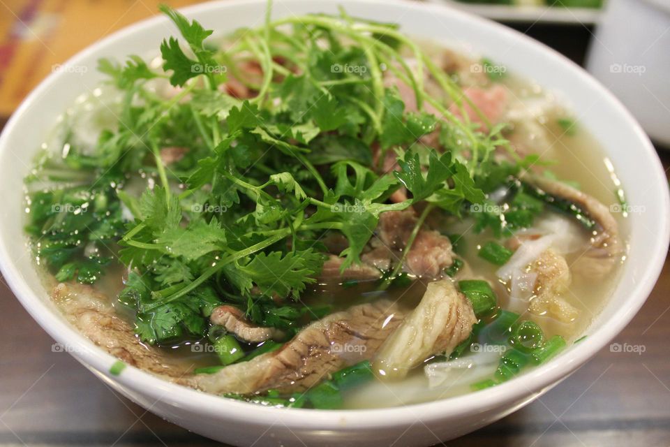 Vietnamese Pho with a lot of green coriander on top.