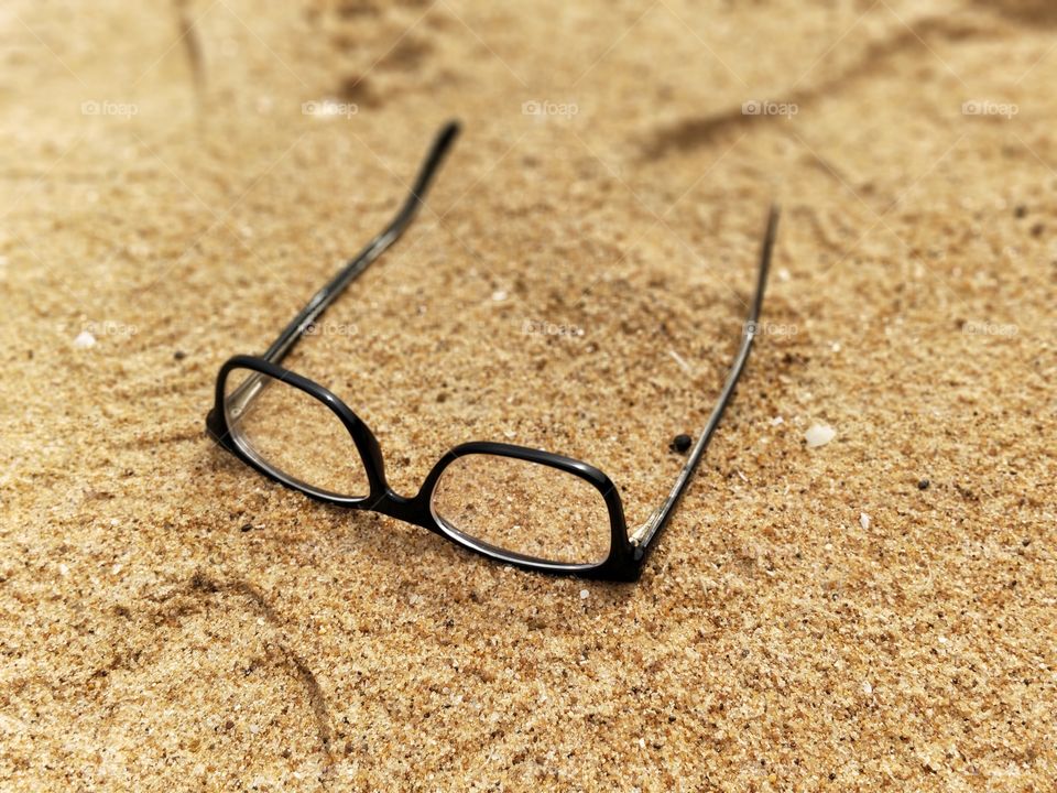 spectacles on sand