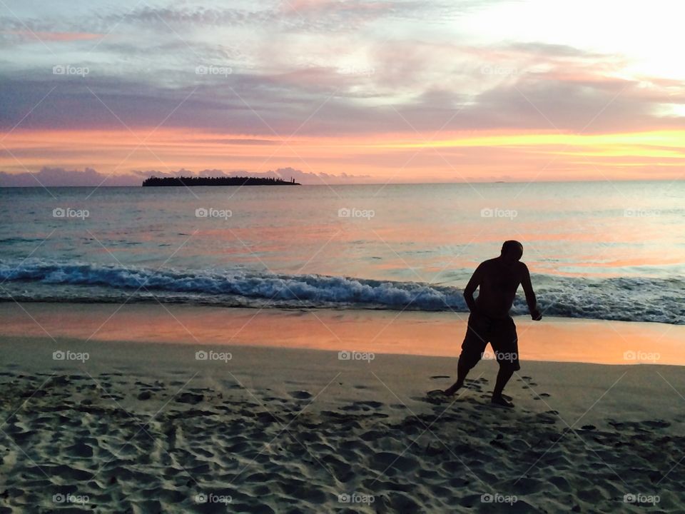 Man doing tai chi on a beach paradise sunset
