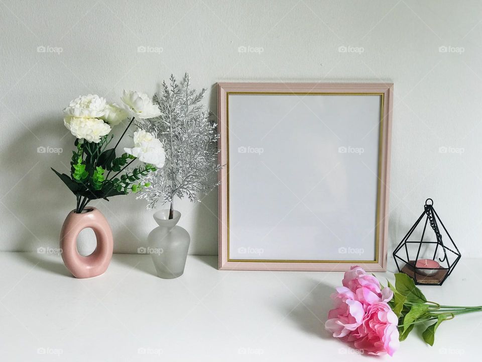 A beautiful pink photo frame and bunch of pink flowers along with pink vases and pink candle in holder on white table looking very pretty 😍