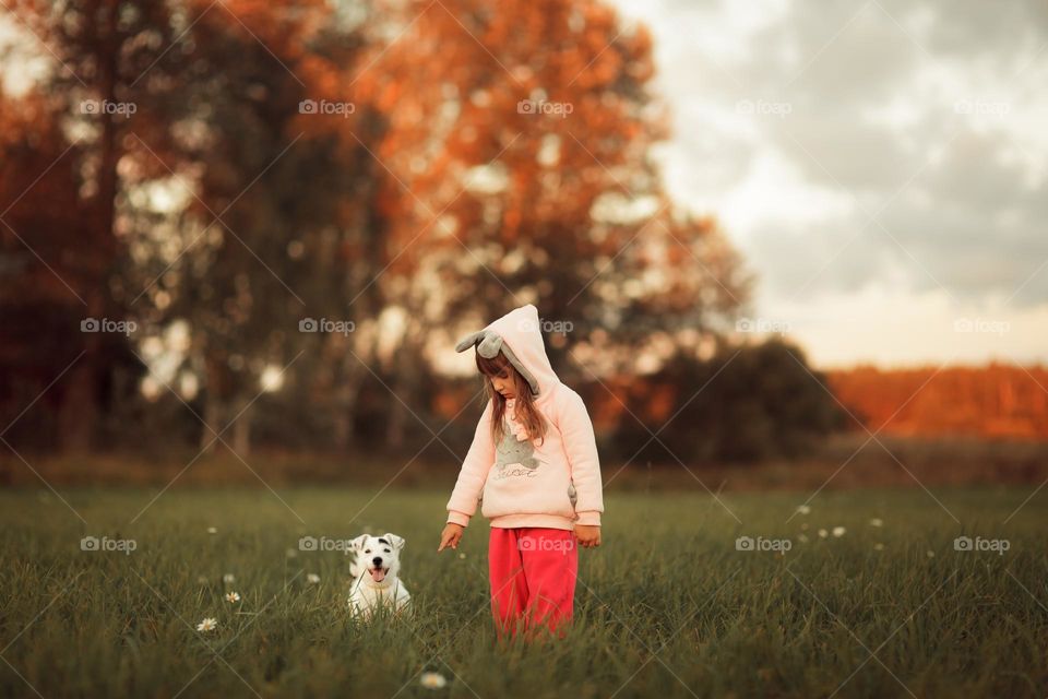 Little girl with small dog outdoor portrait at sunset