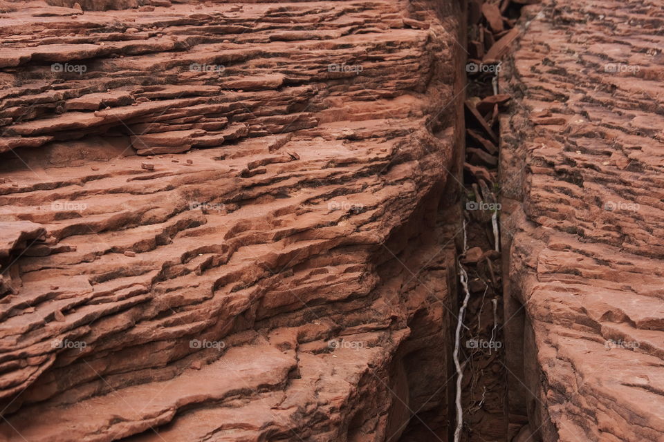 Layers of red sandstone converge.