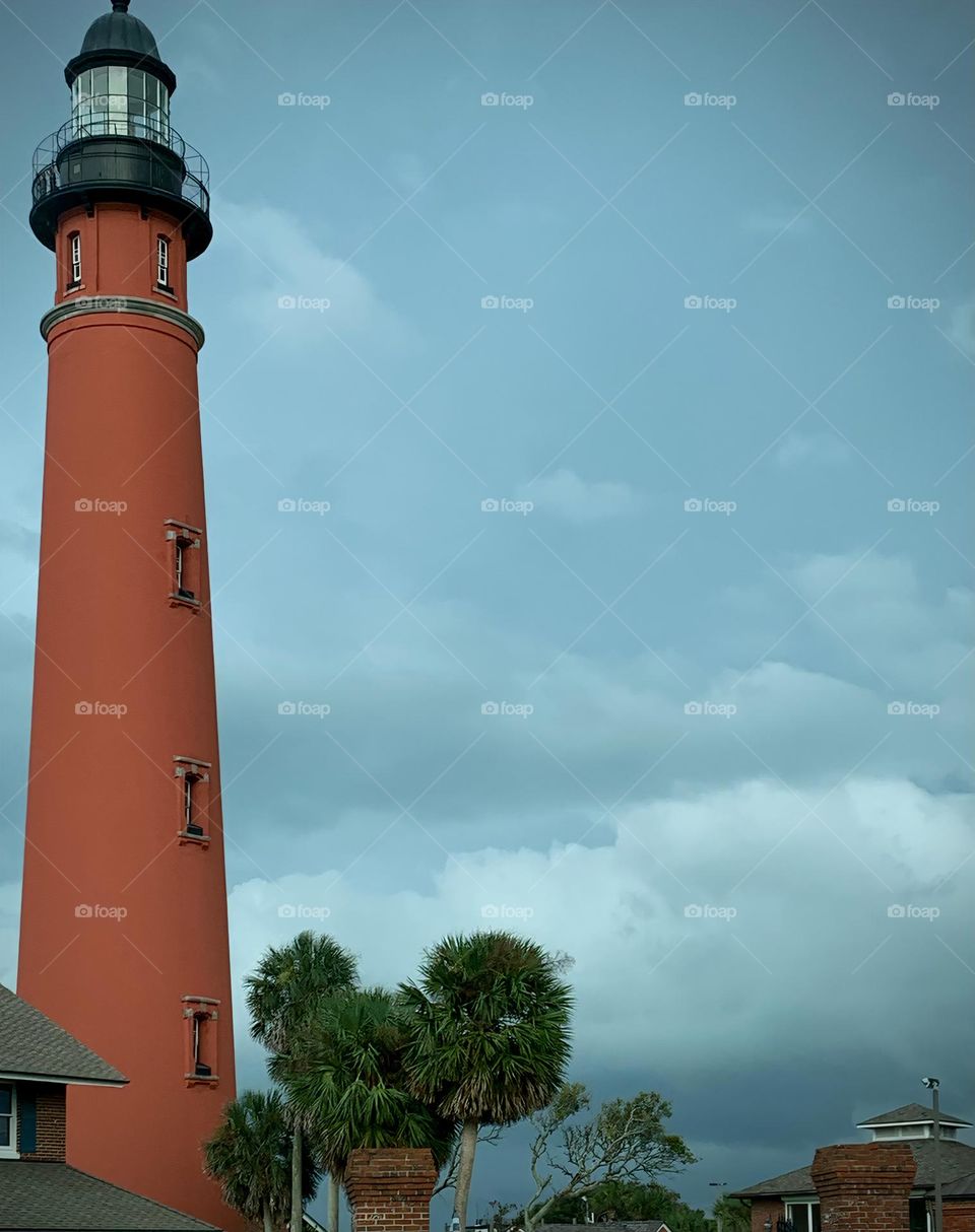 Ponce Inlet Lighthouse, also called the Mosquito Inlet Lighthouse, with brown farm house style museum store. The current tower was lit in 1887 and stands 175 feet tall, making it the tallest lighthouse in Florida, third in the USA.