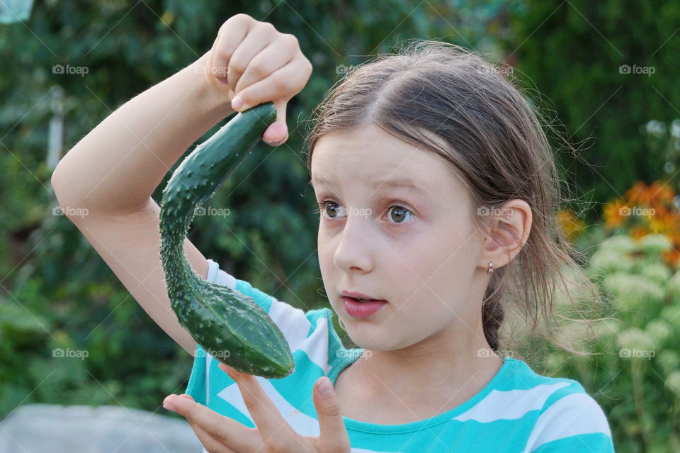 Girl holding an unusual cucumber