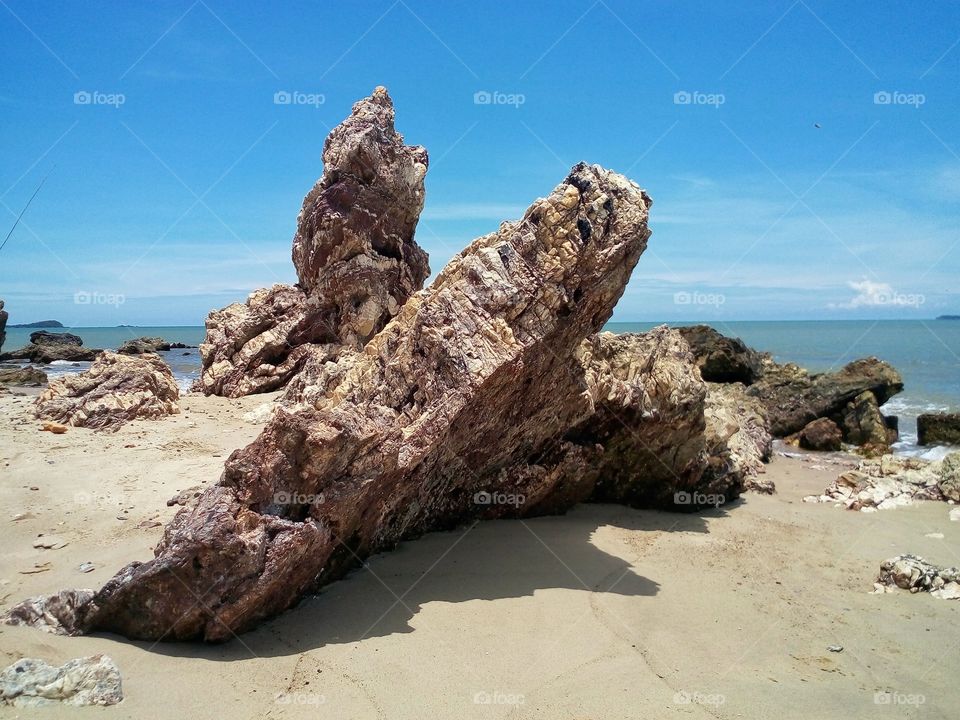 The rocks at the seashore and blue sky background