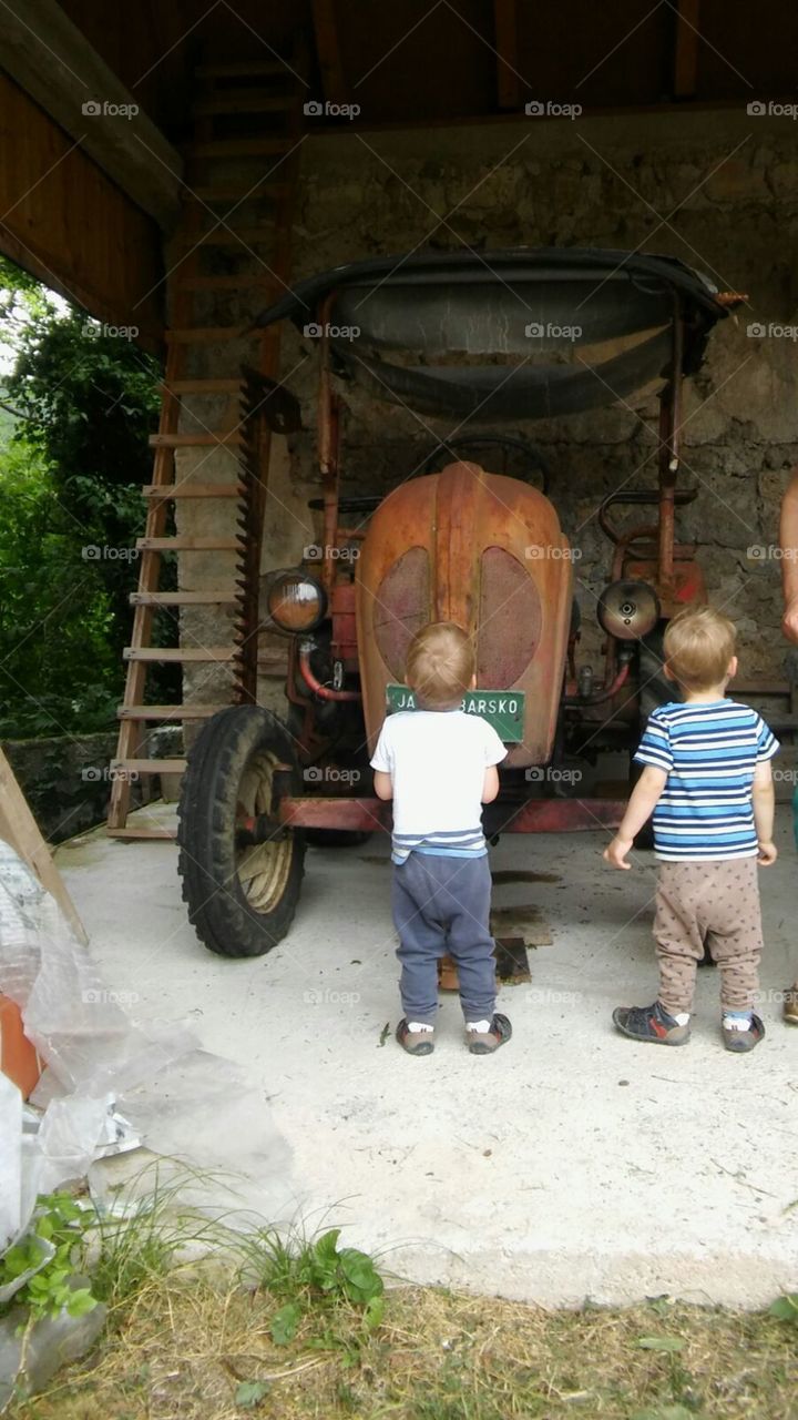 Fastination of little boys with old tractor
