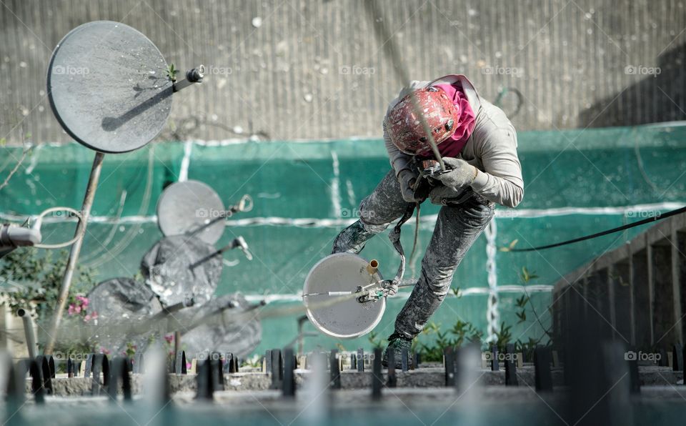 Worker abseiling down side of building in Kuala Lumpur Malaysia