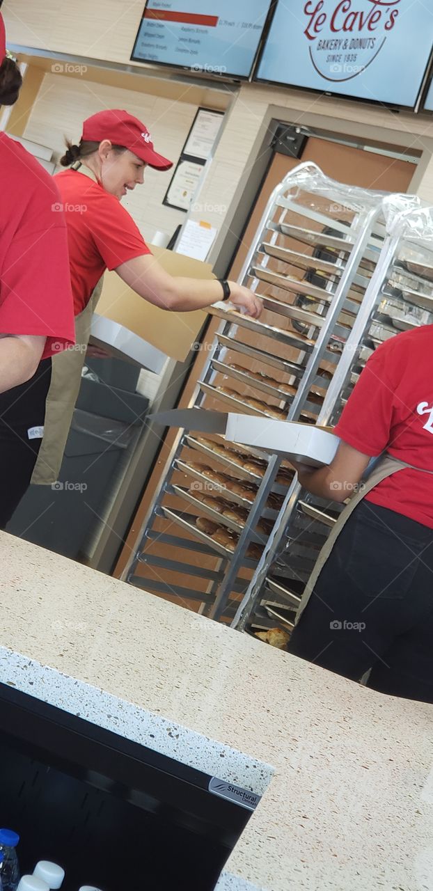doughnuts going out by the dozen in the new location of this old bakery.