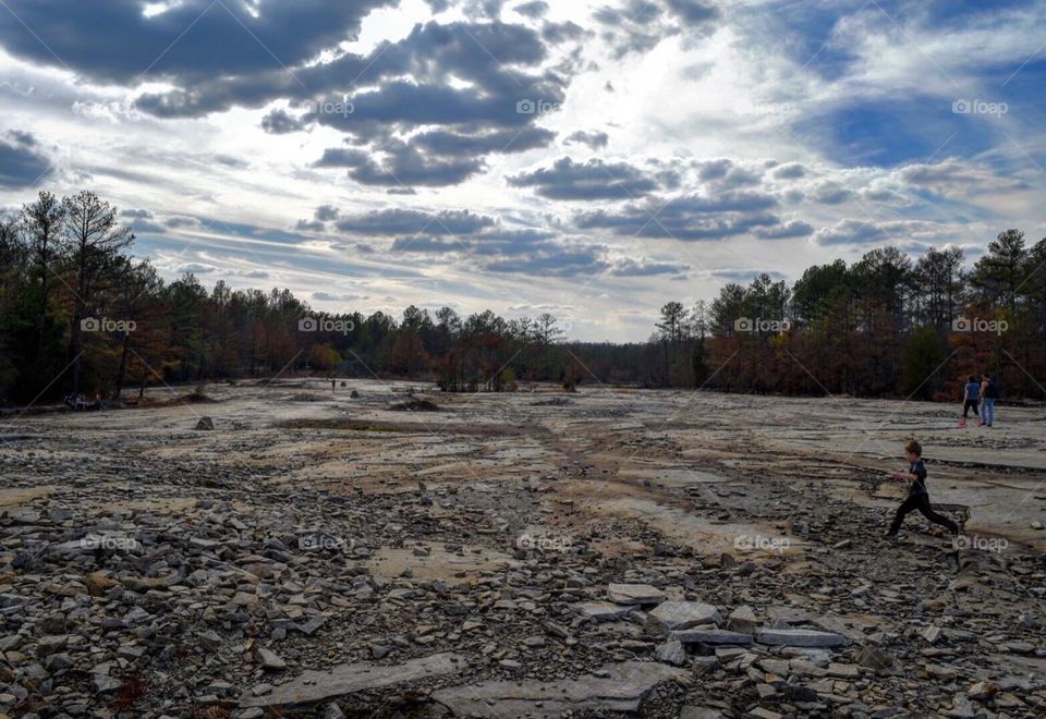 Boy running across a rocky plain
