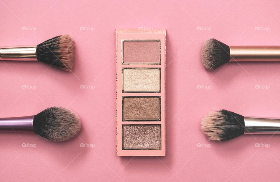 Flat play photo of make-up palette and brushes