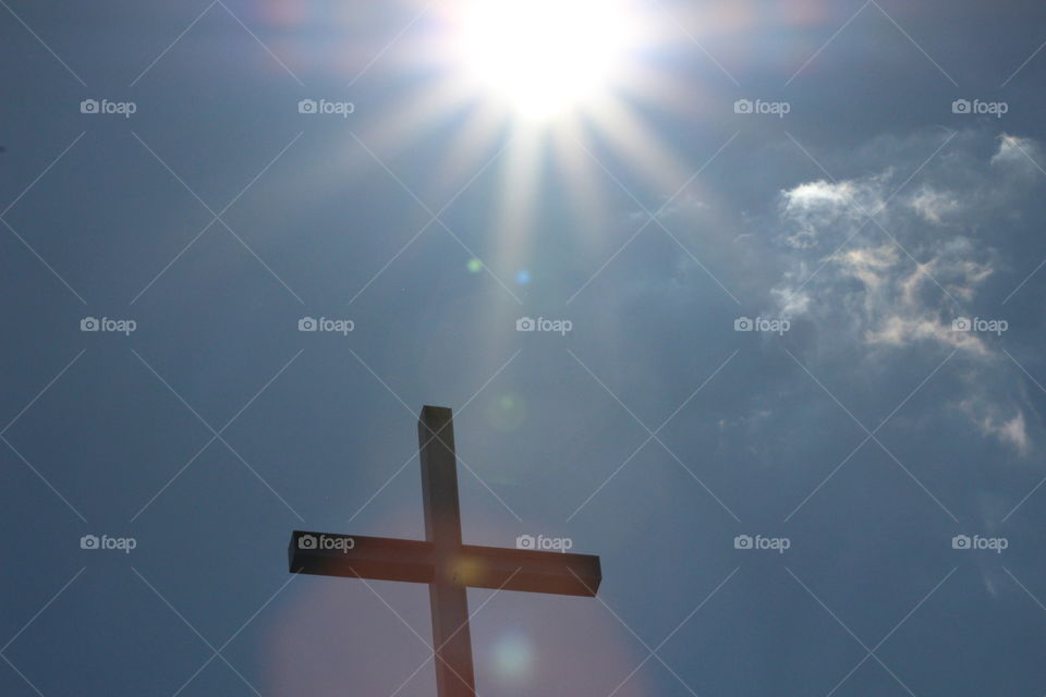 A picture of a cross with the sun shining over it. A very powerful image.