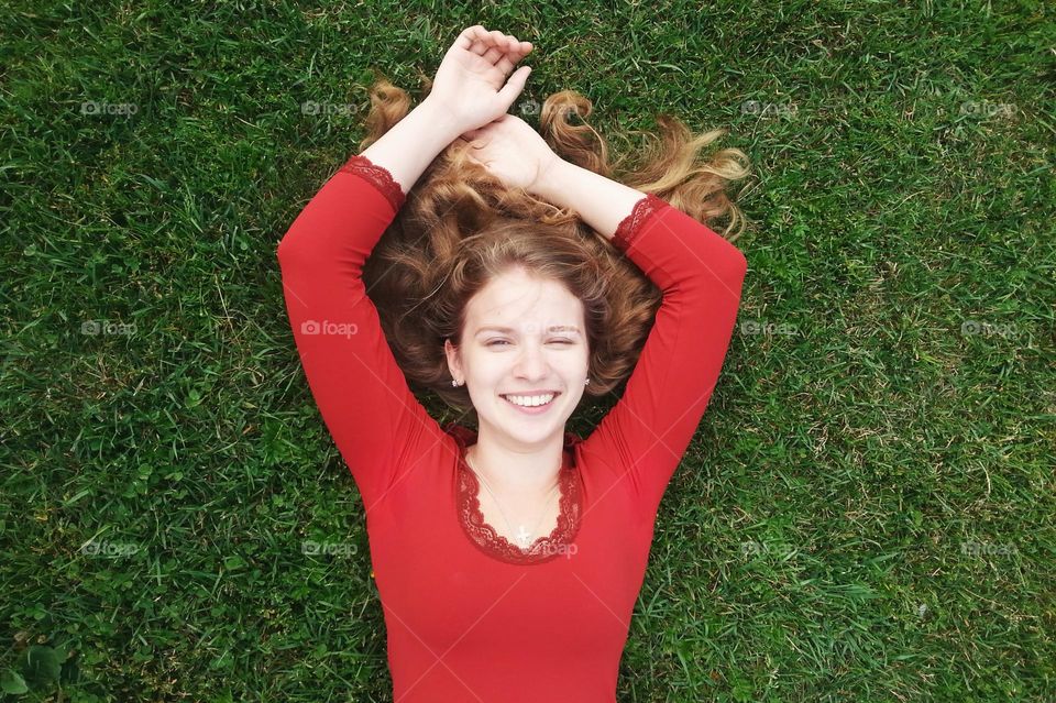 a portrait of a beautiful happy smiling girl on the grass in summer