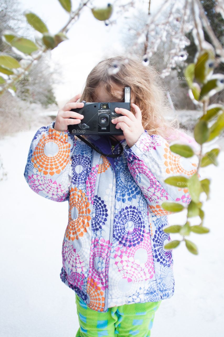 Girl with camera in snow