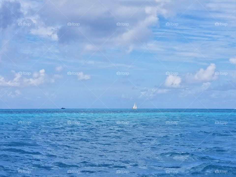 Sailboat and a tiny island off the coast of Antiqua and Barbuda