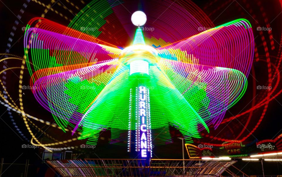 The Hurricane. A carnival ride timelapse at night wiyh brihht colourful light trails
