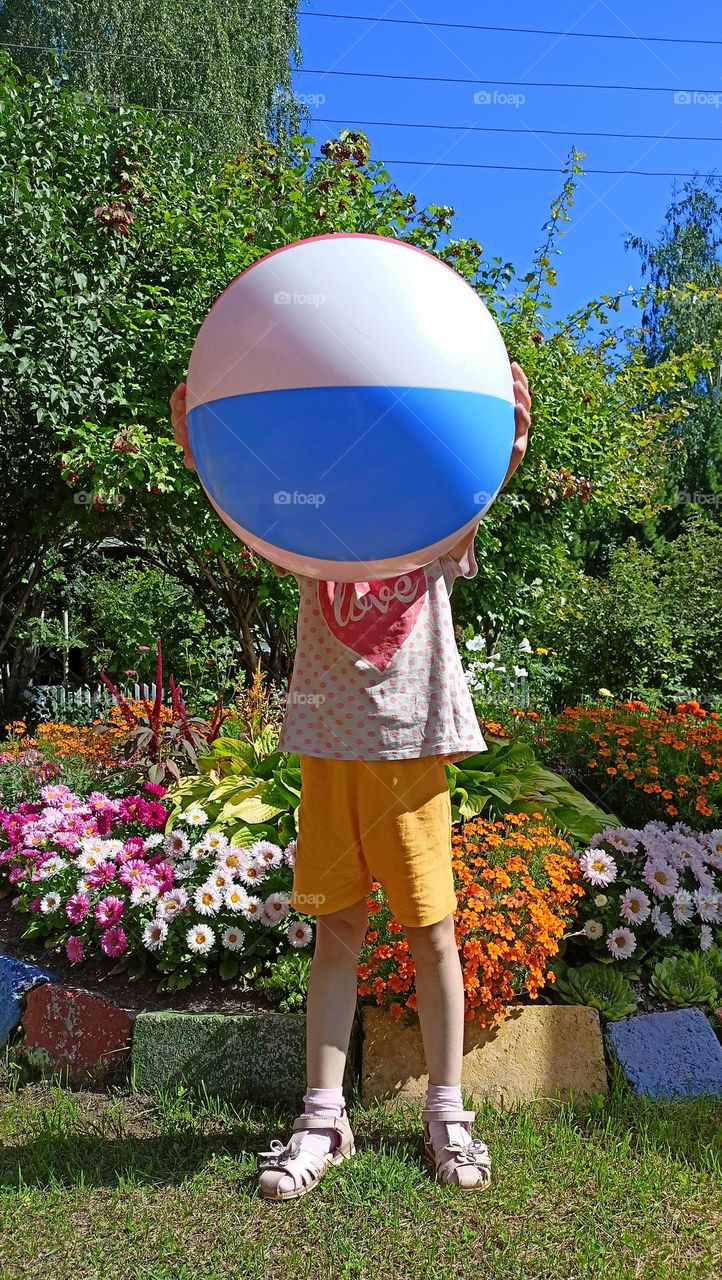 child holding a ball, summer, sun, child, ball, colorful, flowers, flowerbed, great day