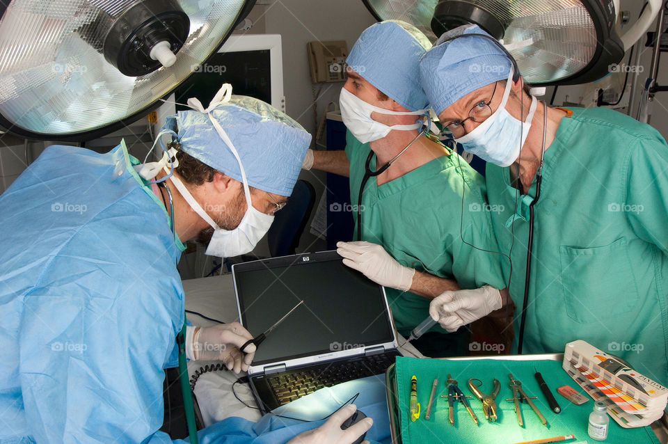 Three men operate on a computer at the emergency room in the hospital