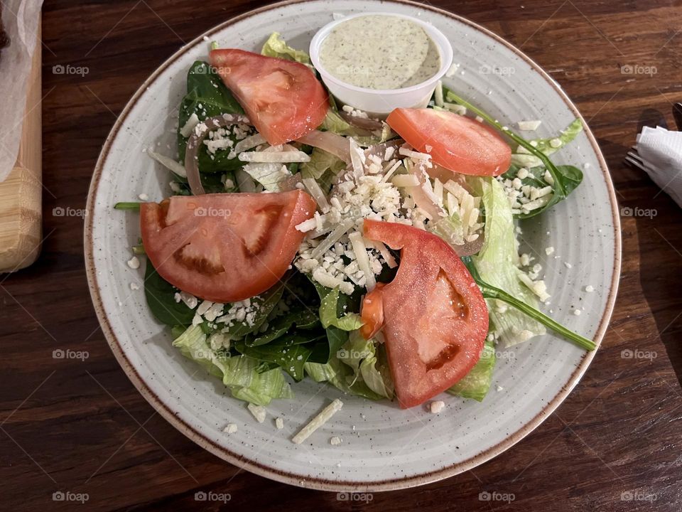 Parmesan Caesar salad on round off white plate.