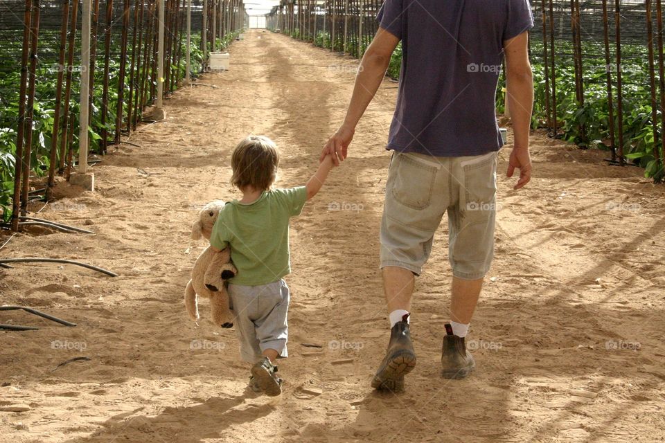 Little boy join his father to work in the field 