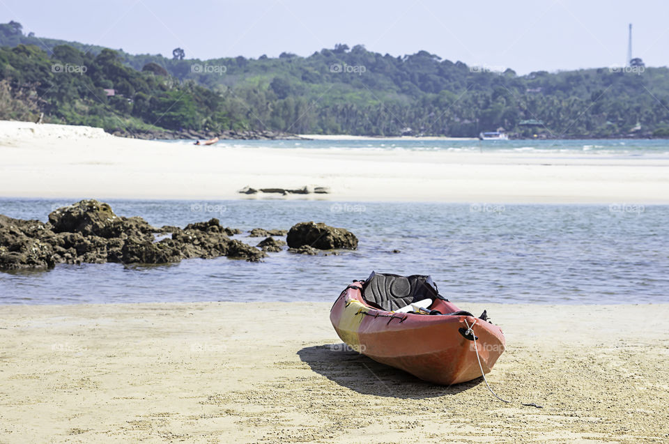 Kayaking on the sand of the sea background mountains and rocks.