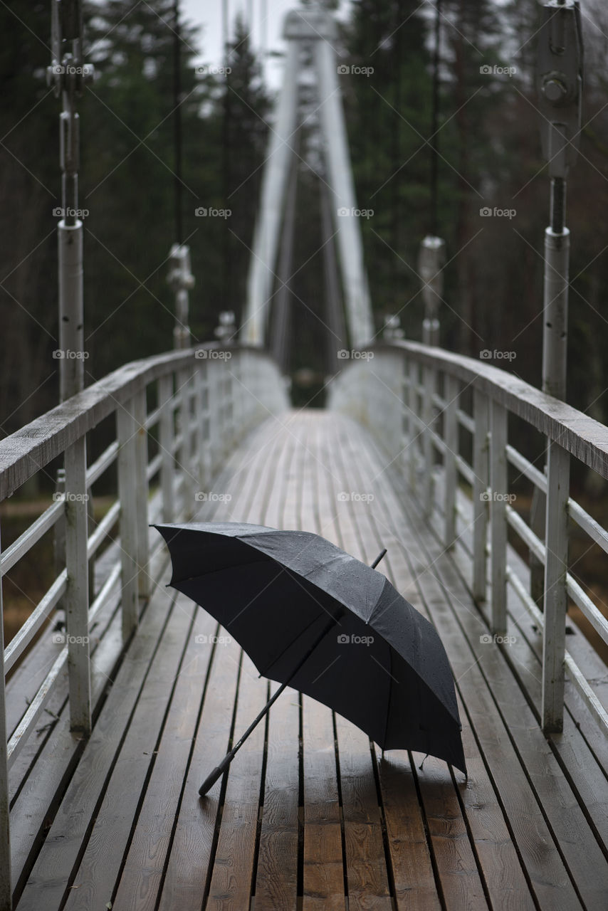Wet umbrella on the pedestrian bridge,rainy day weather concept