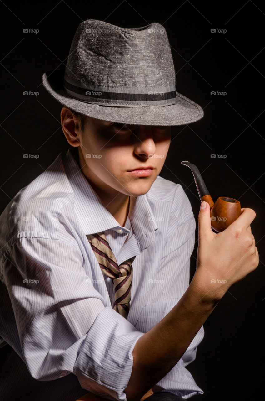 Close-up of a teenage boy smoking pipe