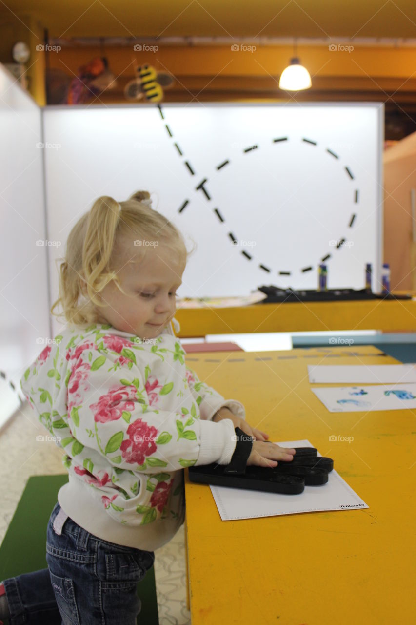 child painting with wood hand