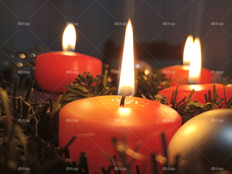 A closeup view of advent wreath with four flamed candles