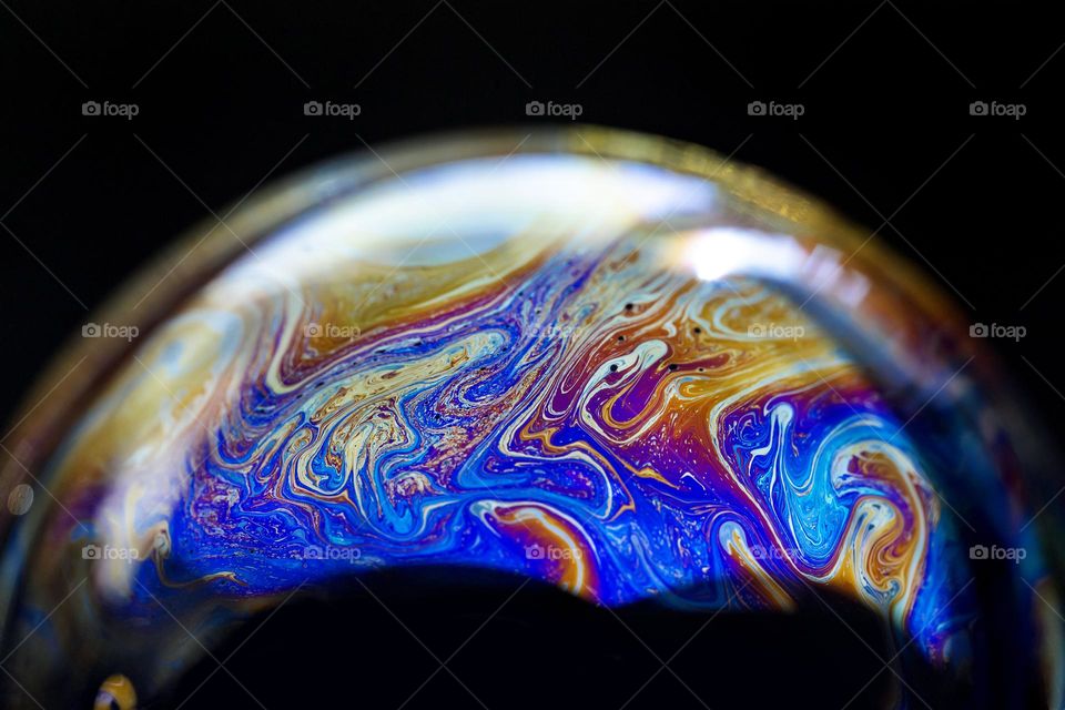 Abstract colorful pattern inside of a soap bubble, macro closeup