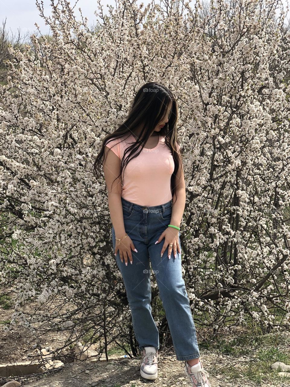 Tall cute mom  among beautiful blooms in the spiring