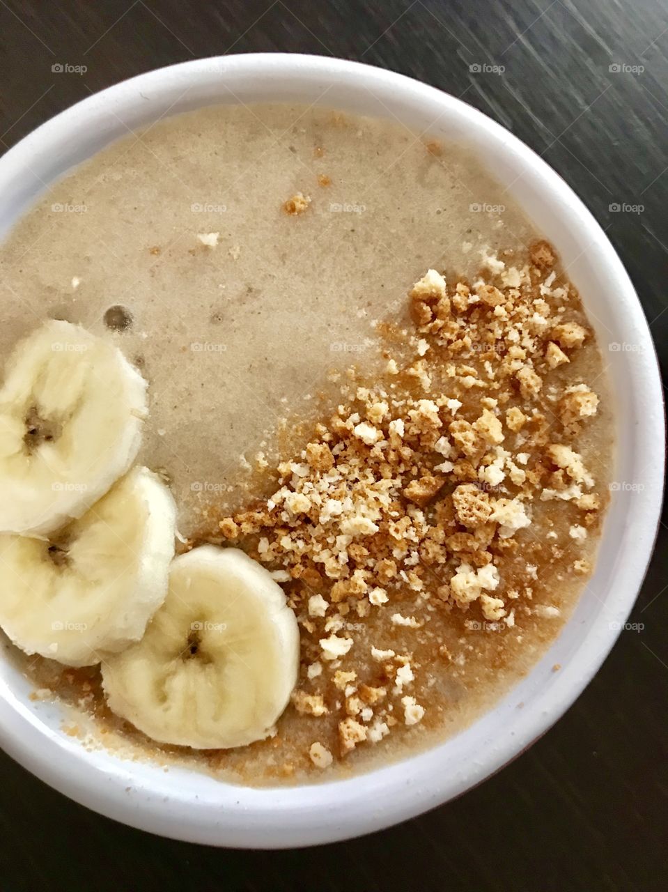 Homemade banana milkshake with crumbled almond biscuits 
